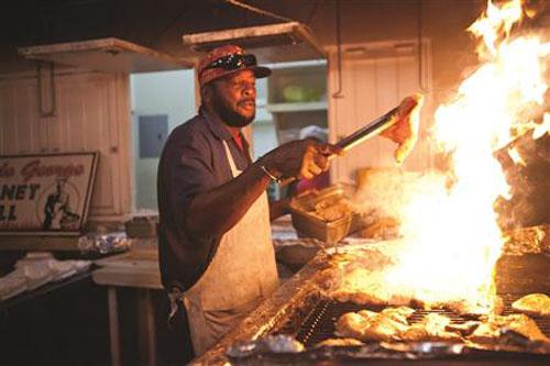 George cooks up  a flaming grilled marlin steak  at Oistin © The Galley Guys